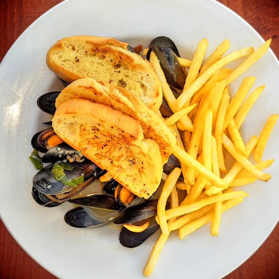 Assiette de moules marinières avec frites et pain grillé, vue de dessus